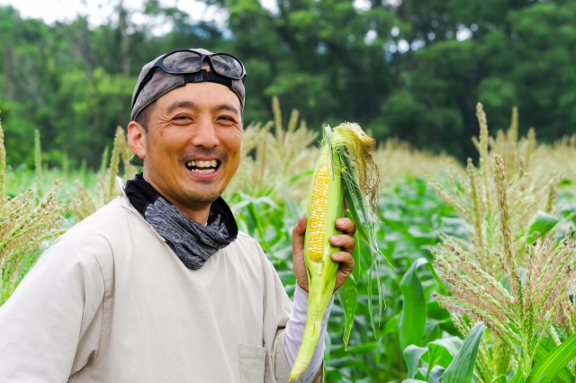 とうもろこしを持つ笑顔の男性