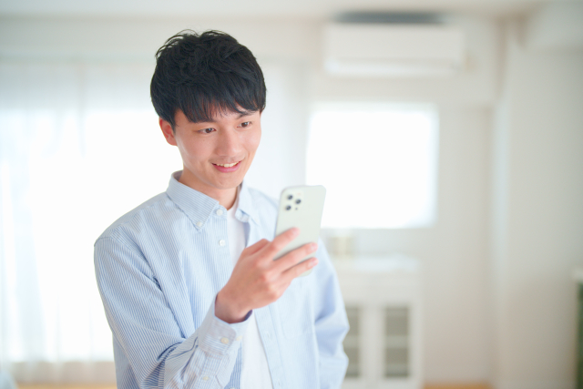 スマホを見ながら笑顔の男性