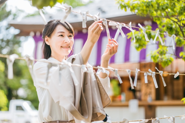 おみくじを結ぶ女性