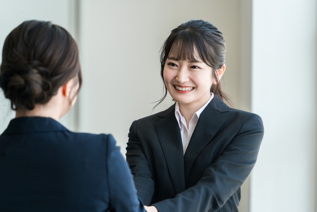 オフィスで同僚と会話する女性