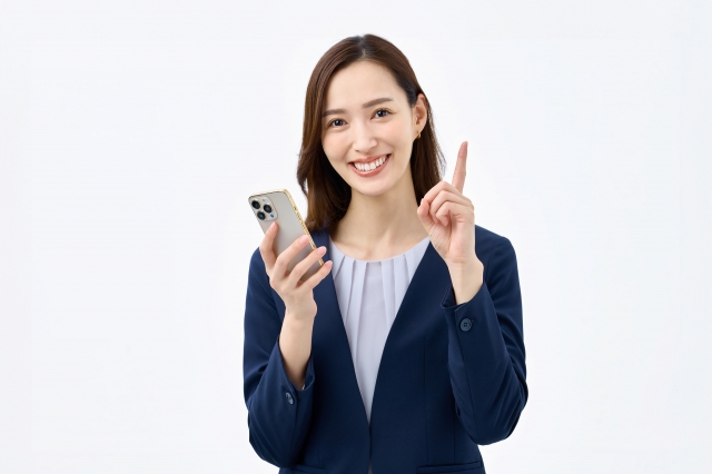 スマホを持った指差し女性