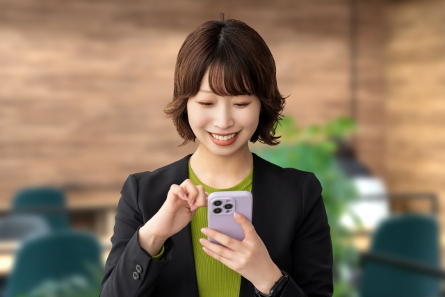 笑顔でスマホを見る女性