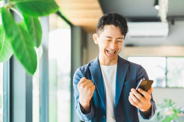 笑顔でスマホを見る男性