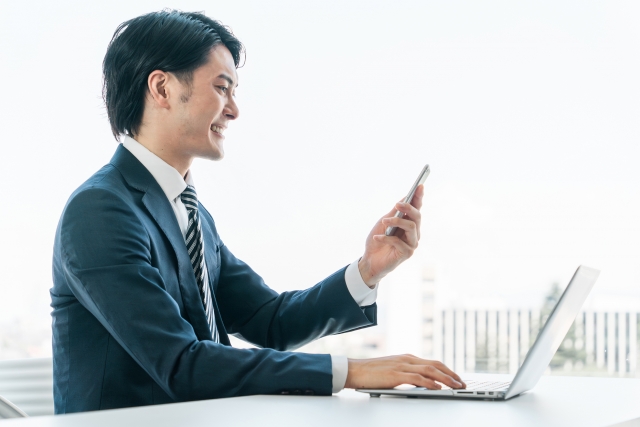 笑顔でスマホを見る男性